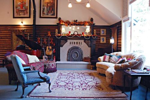 Cozy living room with a fireplace, plush seating, musical instruments, and decorative artwork on the walls.
