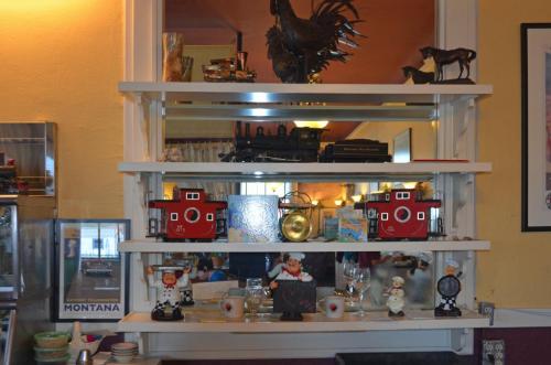 A shelf displaying various collectibles, including a rooster statue, toy trains, and decorative figurines.