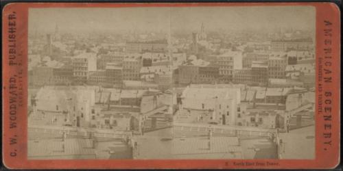 A historic stereoscopic view of a city skyline, showcasing rooftops and distant buildings from a tower perspective.