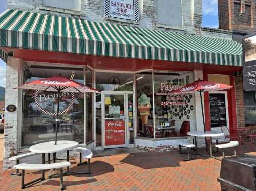 Exterior of Payne's Sandwich Shop with striped awning, outdoor seating, and a Coca-Cola sign. Bright, sunny day.