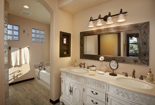 Elegant bathroom featuring a double vanity, large mirror, and a freestanding bathtub with natural light.