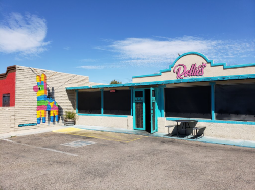 Colorful restaurant exterior with a piñata mural on the side and bright blue accents on the entrance.