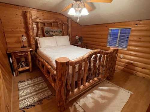 Cozy log cabin bedroom featuring a wooden bed, nightstand, and rustic decor with warm lighting.