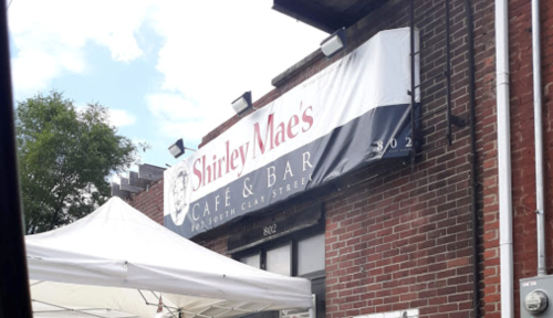 Sign for Shirley Mae's Café & Bar, located on North Clark Street, with a tent in the foreground.