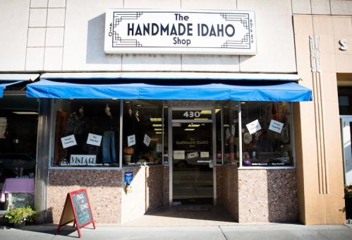 Front view of The Handmade Idaho Shop, featuring a blue awning and various handmade items displayed in the windows.