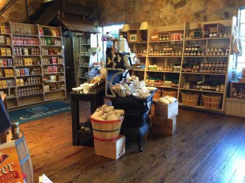 A cozy store interior filled with shelves of jars, baskets, and various packaged goods on wooden floors.