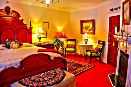 Cozy bedroom with a wooden bed, decorative lamps, a small table, and a fireplace, featuring warm lighting and rich colors.