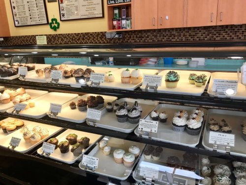 A display case filled with various cupcakes, featuring different flavors and colorful frosting.