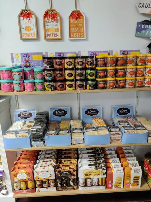 A colorful display of various jars, snacks, and treats on shelves, featuring pumpkin-themed products and seasonal items.