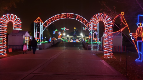 Colorful holiday lights illuminate the entrance to Lafreniere Park, featuring festive decorations and a Christmas tree.