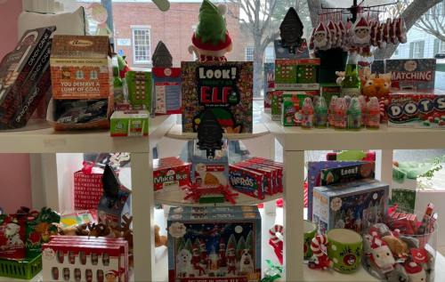 A festive display of holiday-themed toys and treats, including games, candies, and decorations in a cheerful setting.