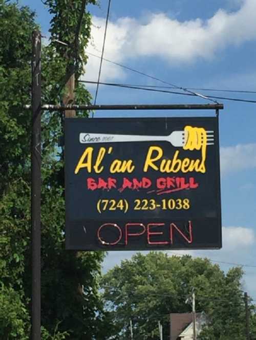 Sign for Al'an Rubens Bar and Grill, featuring a fork and the text "OPEN," with a phone number below.