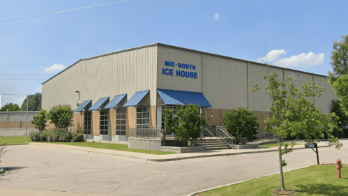 Exterior view of the Mid-South Ice House, featuring a large metal building with a blue roof and landscaped surroundings.