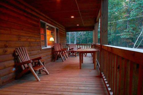 A cozy wooden porch with several chairs and a table, surrounded by trees in a serene setting.