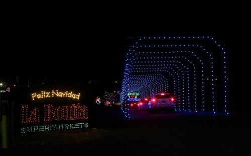 A festive light display with blue and colorful lights, featuring a sign for "La Bonita Supermercado" in the foreground.