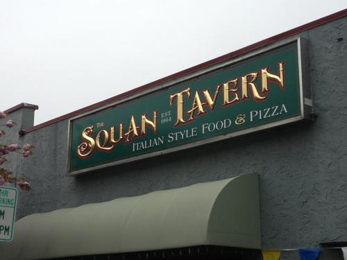 Sign for Squan Tavern, established 1964, featuring Italian style food and pizza.