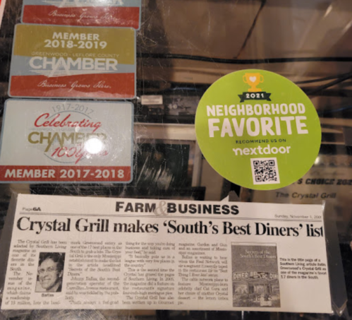 A newspaper clipping about Crystal Grill making the 'South's Best Diners' list, alongside membership badges and a sticker.