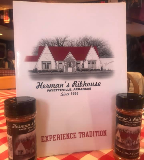 Menu cover for Herman's Ribhouse in Fayetteville, Arkansas, with seasoning bottles on a checkered tablecloth.