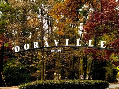 Sign reading "Doraville EST 1871" surrounded by colorful autumn trees.