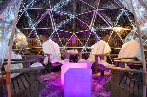 Cozy igloo-style seating area with plush chairs, a glowing table, and twinkling lights, creating a warm atmosphere.