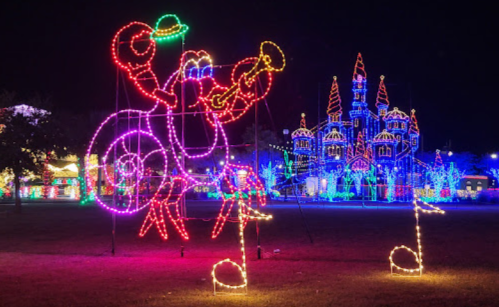 A colorful light display featuring a musical lobster and a brightly lit castle in the background.