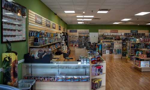 A brightly lit game store interior with shelves of board games, collectibles, and a display counter.