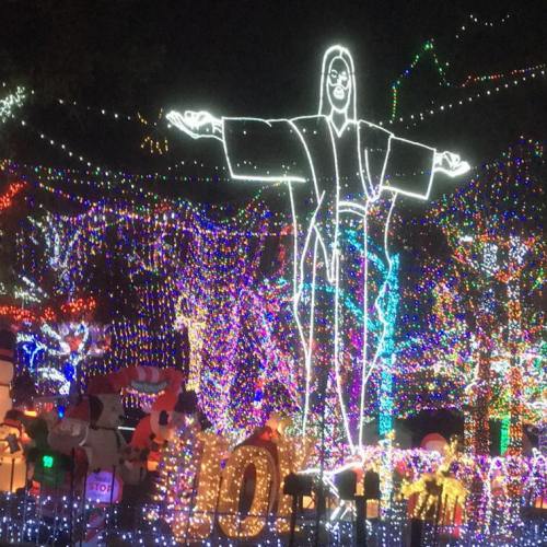 A glowing figure surrounded by colorful holiday lights, creating a festive atmosphere at night.