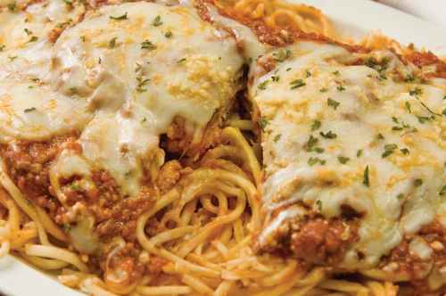 A plate of spaghetti topped with marinara sauce and melted cheese, garnished with parsley.
