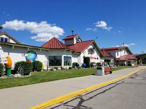 Colorful building with a whimsical design, featuring a red roof and decorative elements, set against a blue sky.