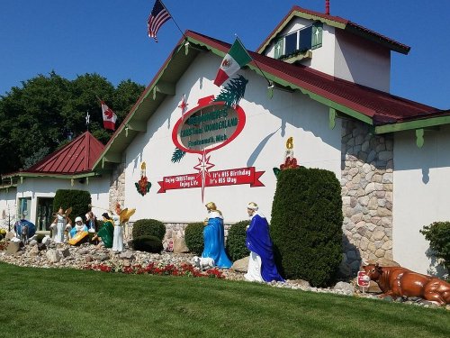 Colorful building with festive decorations, featuring a nativity scene and flags of Canada and Mexico.