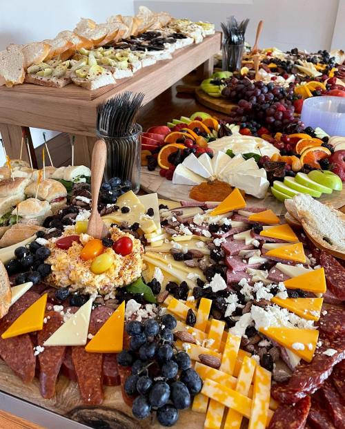A vibrant charcuterie board featuring cheeses, meats, fruits, and breads arranged beautifully on a wooden table.