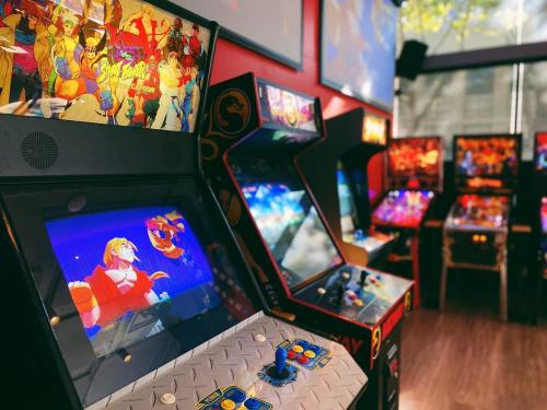A vibrant arcade with classic video game machines featuring colorful screens and retro designs.