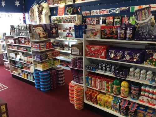 A colorful shop interior filled with shelves of various candies, chocolates, and festive decorations.