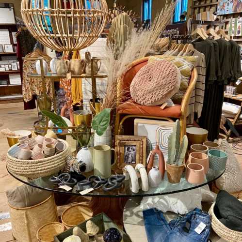 A cozy display of home decor items, including plants, ceramics, and textiles, arranged on a circular table.