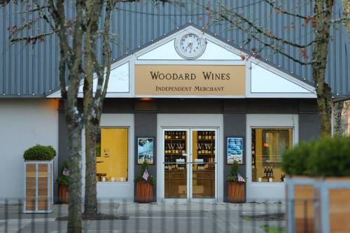 Exterior of Woodard Wines, an independent merchant, featuring a clock and large windows with wine displays.