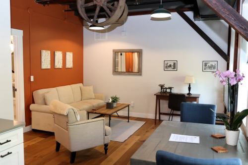 Cozy living space with a beige sofa, wooden table, and decorative wall art in a modern setting.