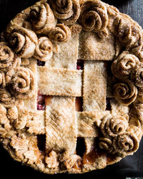 A beautifully baked pie with a lattice crust and decorative rose-shaped edges, showcasing a golden-brown finish.