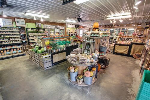 A vibrant farm store interior filled with fresh produce, jars, and seasonal decorations, showcasing a rustic charm.