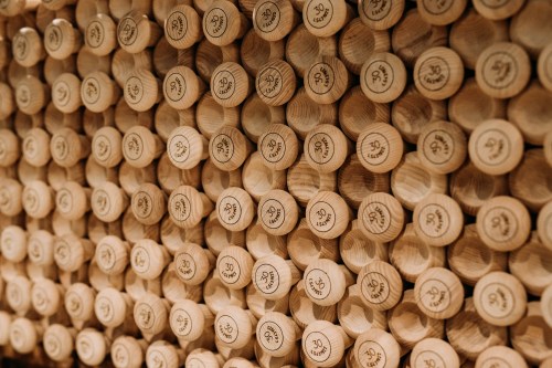 A close-up of neatly arranged wooden corks, each stamped with a logo or number, creating a textured pattern.