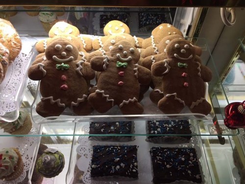 A display of gingerbread cookies shaped like gingerbread men, decorated with icing, alongside chocolate treats.