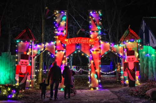 A festive entrance decorated with colorful lights and nutcracker figures, welcoming visitors on a winter night.