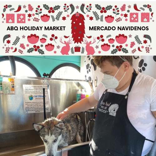 A person bathes a dog at the ABQ Holiday Market, surrounded by festive decorations.