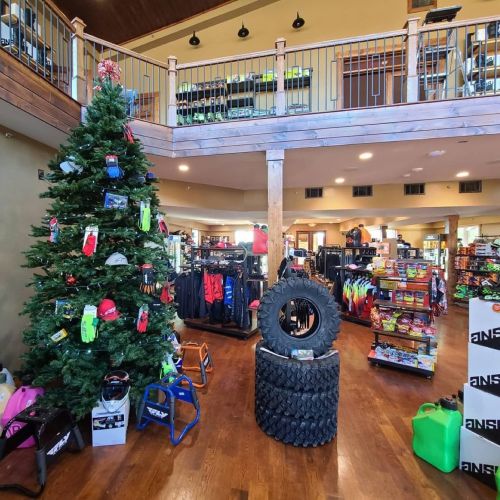 A spacious retail store featuring a decorated Christmas tree, athletic gear, and colorful merchandise displays.