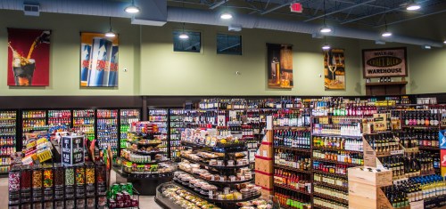 A well-organized store interior featuring shelves of beverages, snacks, and colorful displays.