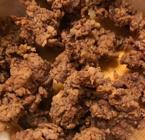 Close-up of crispy, golden-brown fried chicken pieces in a bowl.