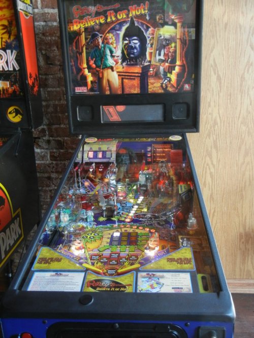 A colorful pinball machine featuring a "Ripley's Believe It or Not!" theme, with vibrant graphics and illuminated playfield.