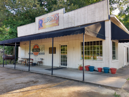 Exterior of Ubon's Restaurant with a sign, awning, and potted plants, set in a rural area.