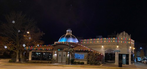 A restaurant at night, adorned with colorful lights and festive decorations, showcasing a charming architectural design.