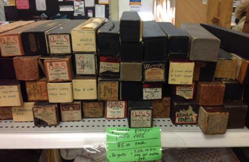 A collection of vintage planter boxes stacked on a shelf, labeled with various names and prices.