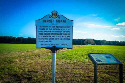 Historical marker for Harriet Tubman in a green field, highlighting her role in the Underground Railroad and the Civil War.